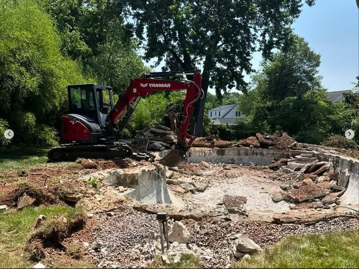 Demolition — breaking down the concrete shell with the excavator