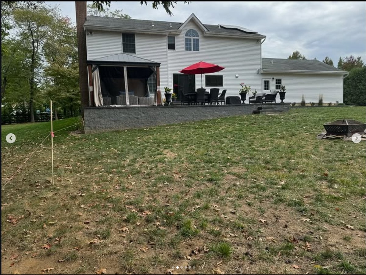 Before — patchy, unusable lawn falling away from the patio
